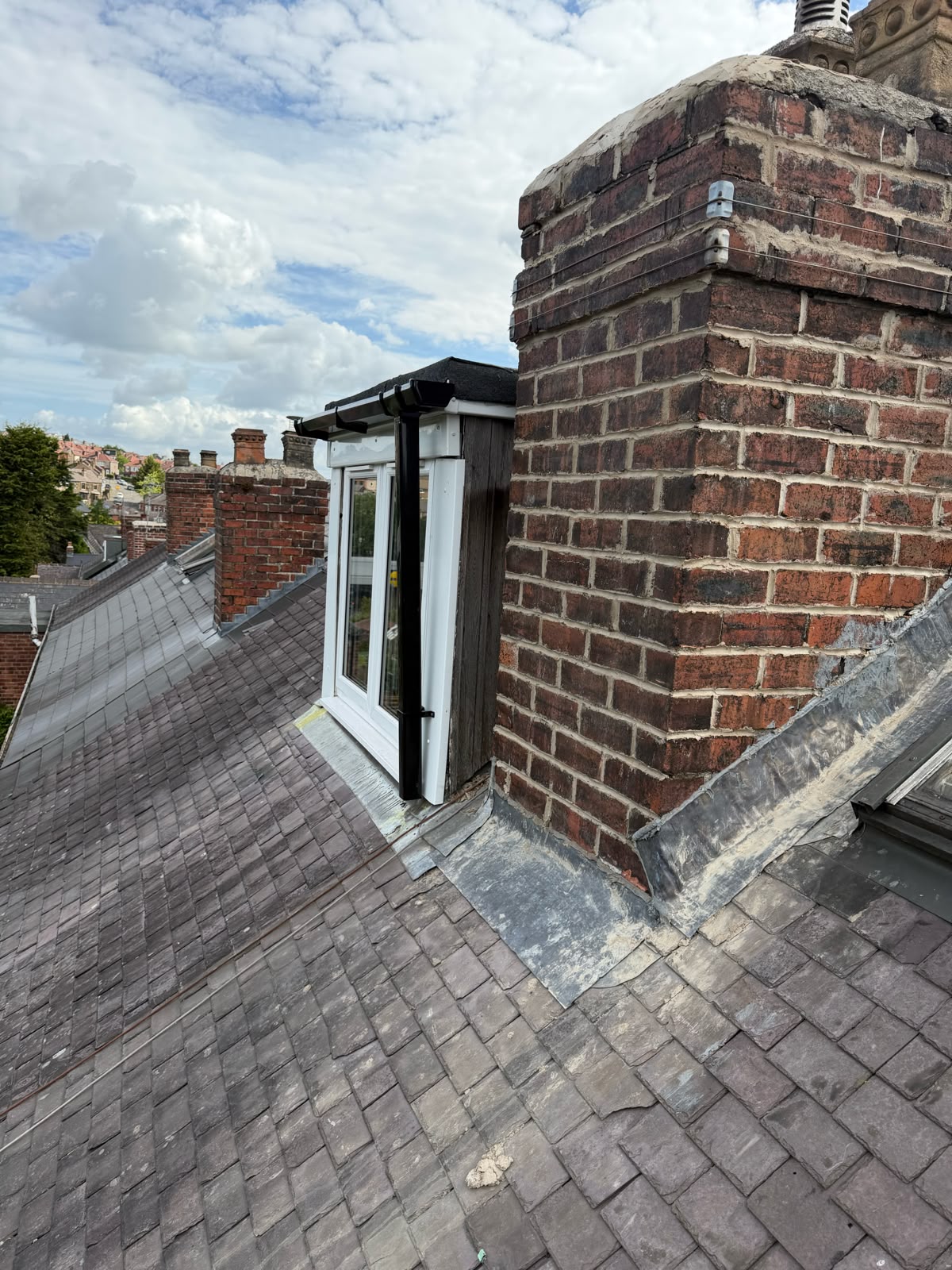 Chimney and surrounding roofing requiring repair